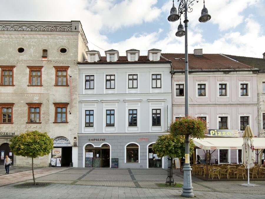 Uma rua com um museu, um restaurante e uma pizzaria.