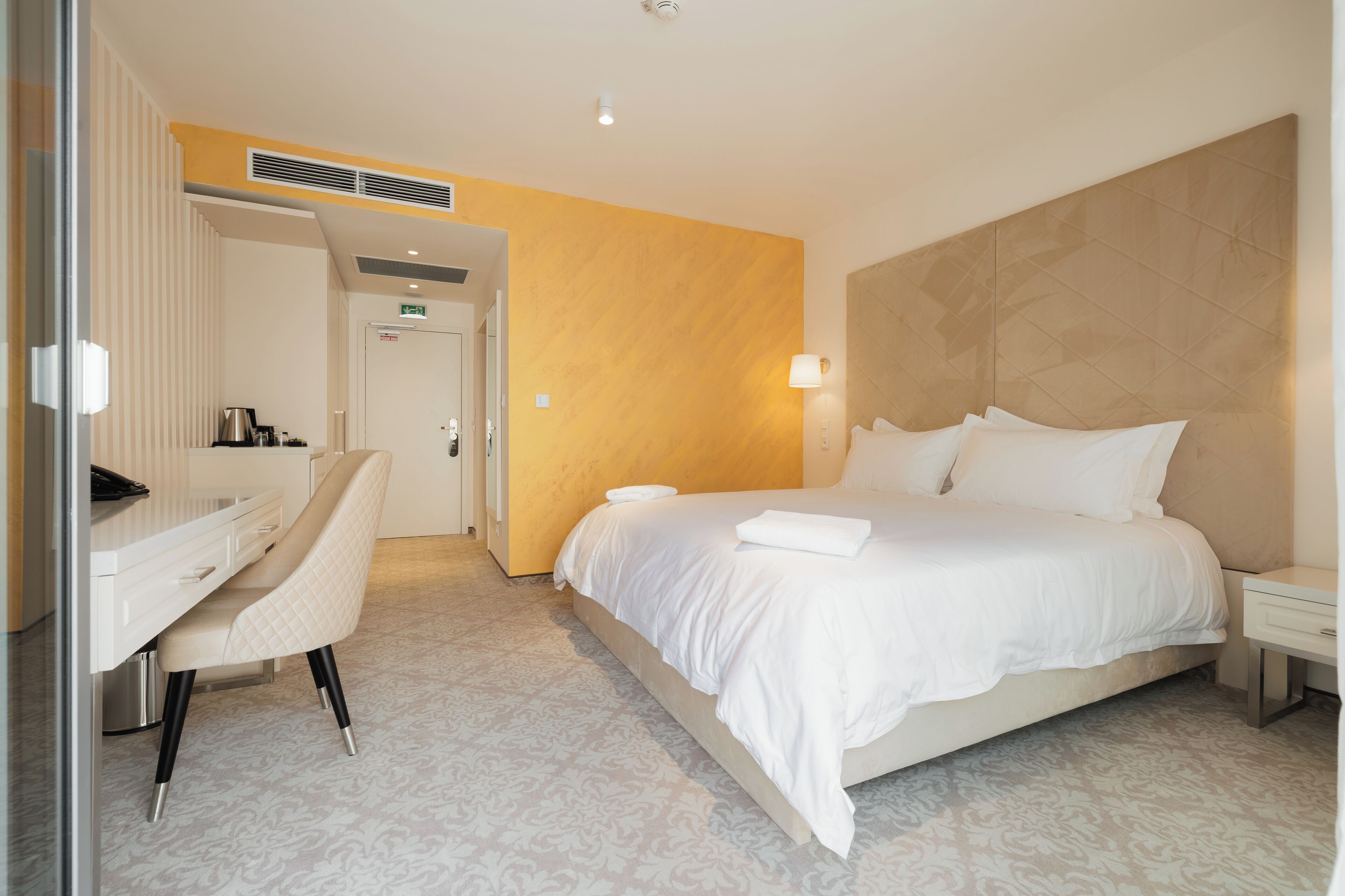 Una camera d'albergo con un letto, una scrivania e una sedia.