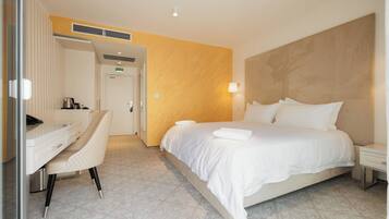 Una camera d'albergo con un letto, una scrivania e una sedia.