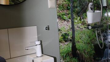 A bathroom with a sink, mirror, and shower.
