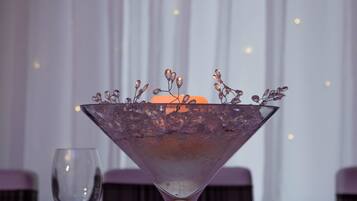 Una mesa dispuesta con un bol de cristal transparente sobre un mantel individual escocés, una copa de vino y cubiertos.