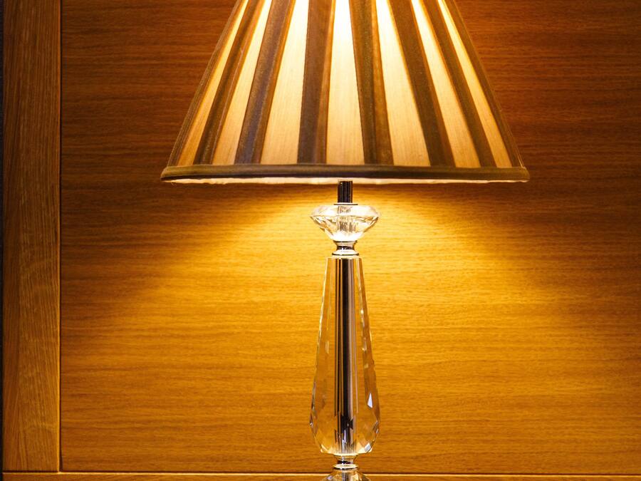 A table lamp with a pleated shade on a wooden surface.