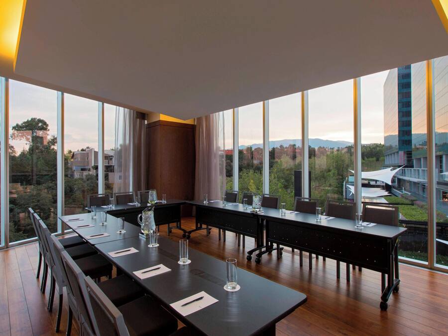 A conference room with large windows, a long table, and chairs.