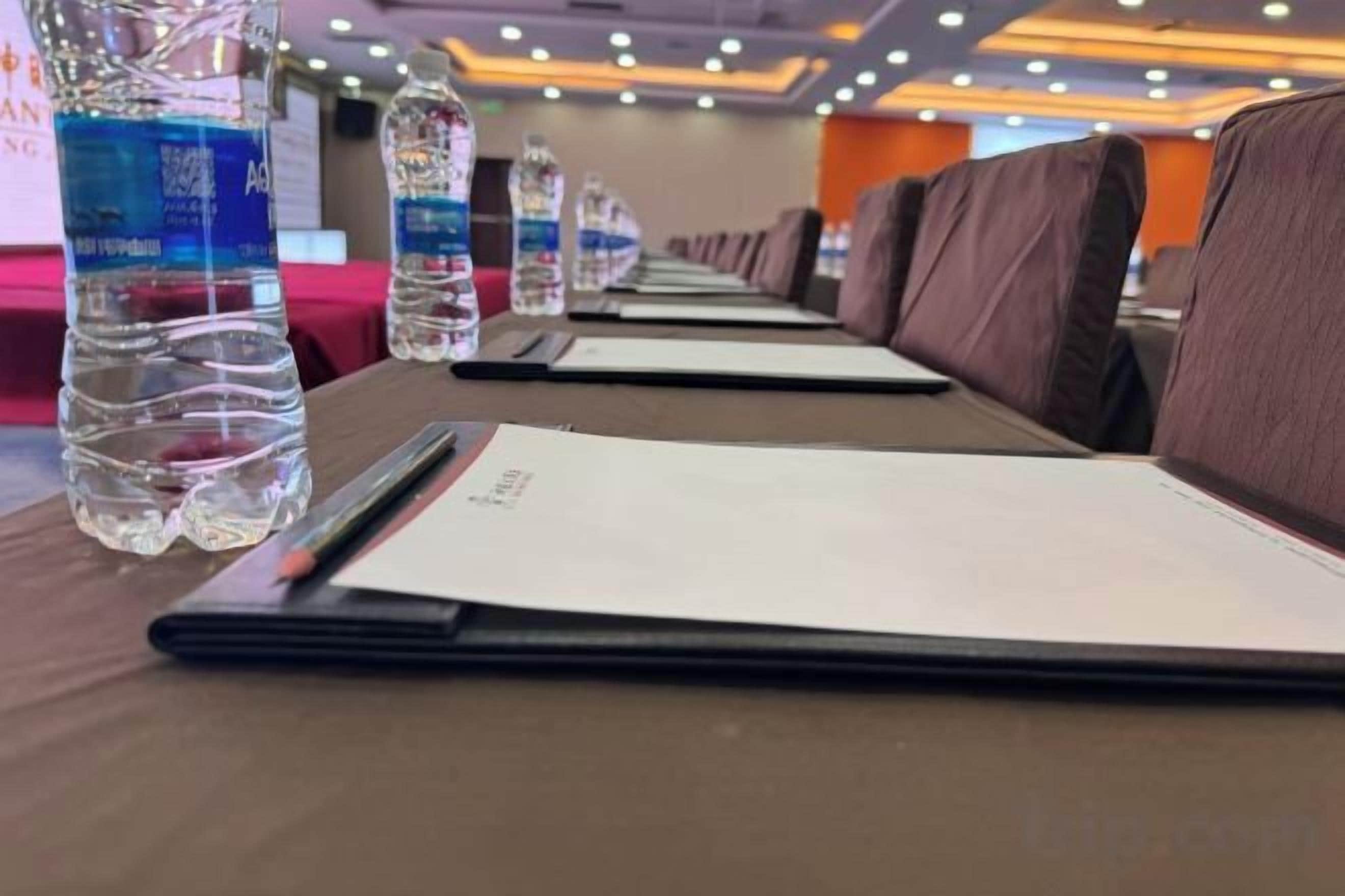 A row of tables with water bottles and menus, indicating a dining area in a hotel.
