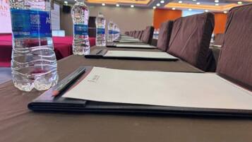 A row of tables with water bottles and menus, indicating a dining area in a hotel.