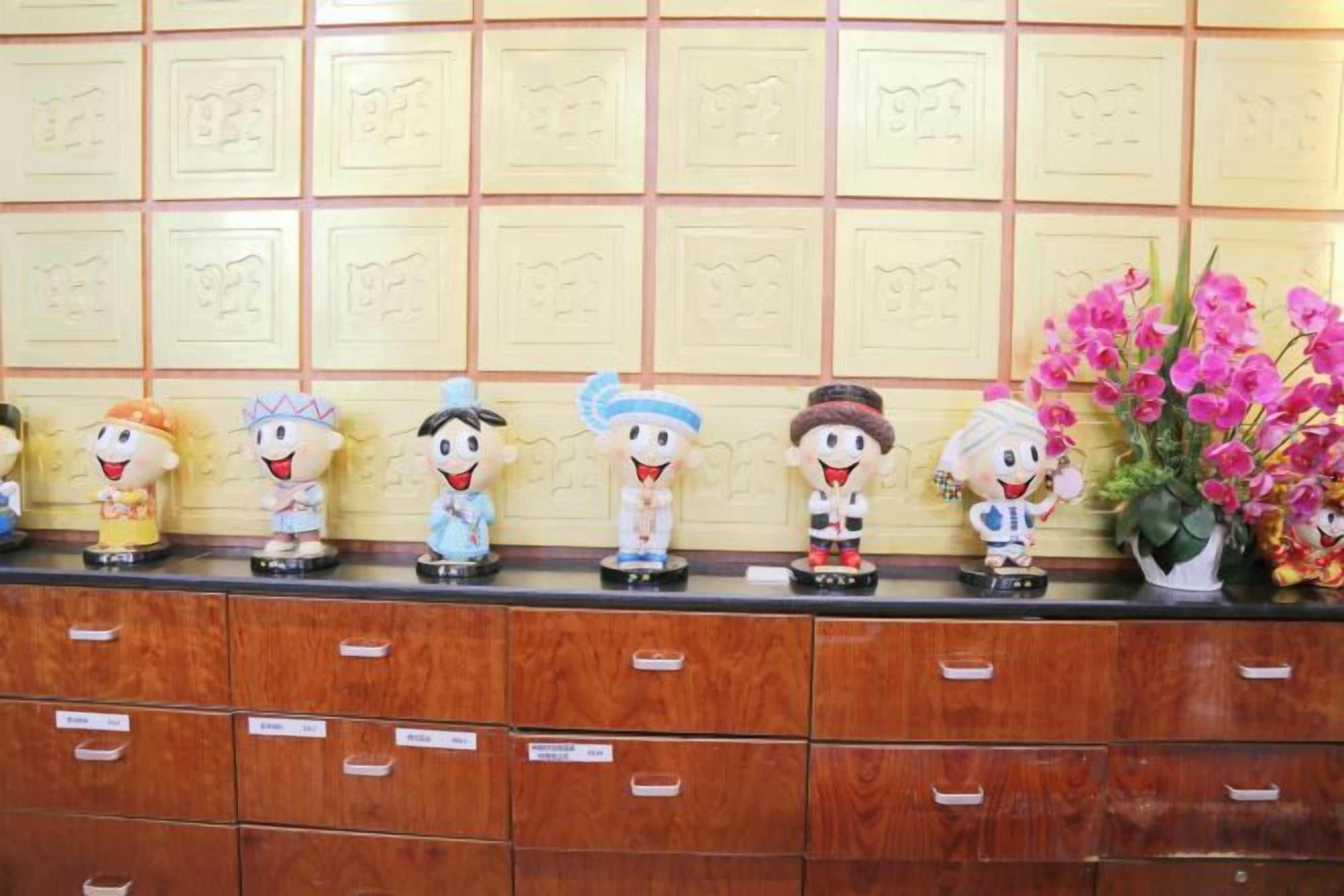 A row of figurines on a counter with drawers below.