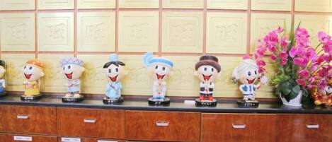 A row of figurines on a counter with drawers below.