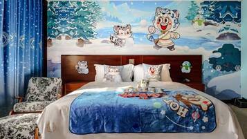 A bedroom with a large bed, a headboard with a Christmas-themed mural, and a blue blanket.