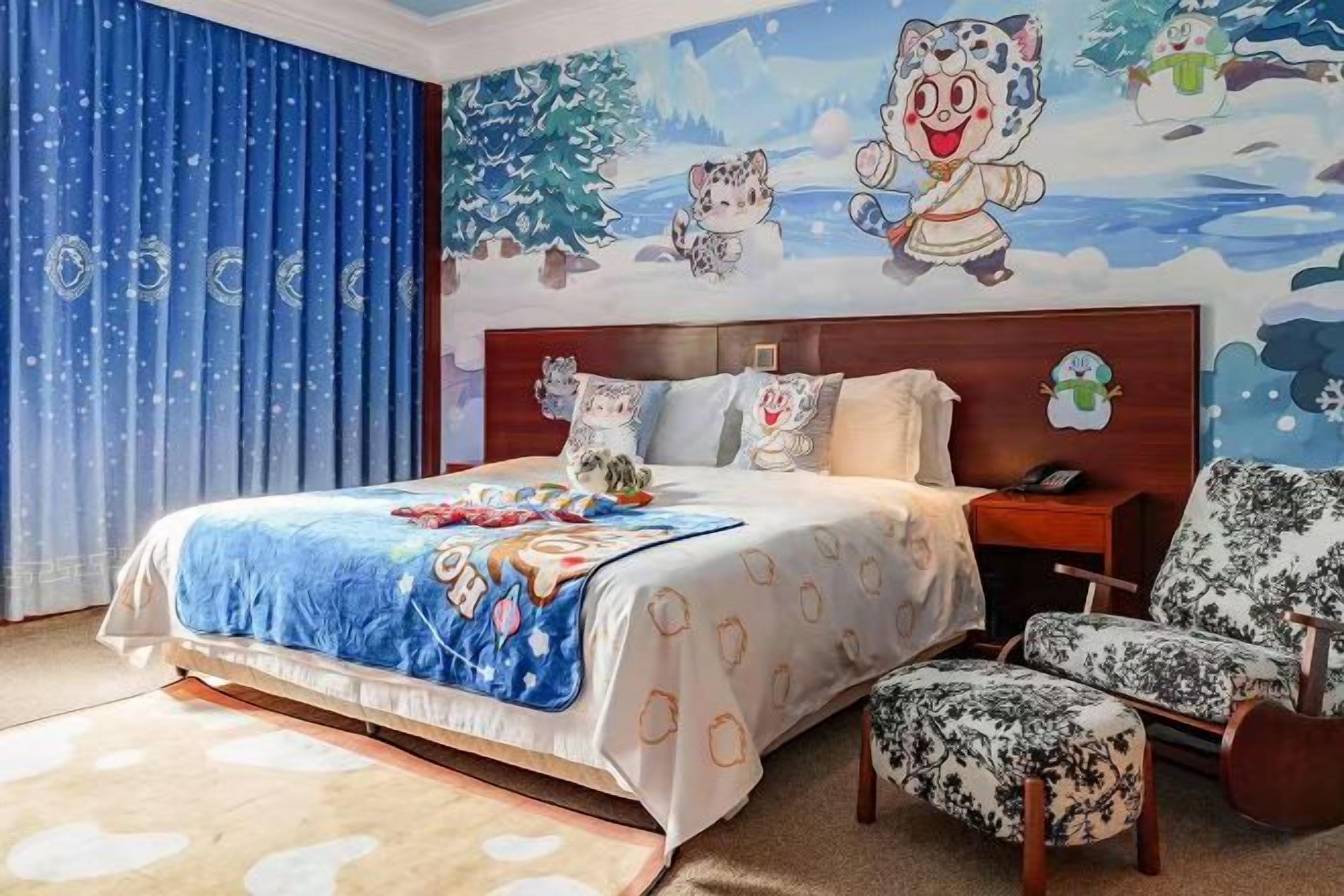 A bedroom with a bed, a nightstand, a chair, and a wall mural.