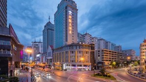 A modern urban hotel with a prominent tower, multiple floors, and a central courtyard. - San Want Hotel (Xining)