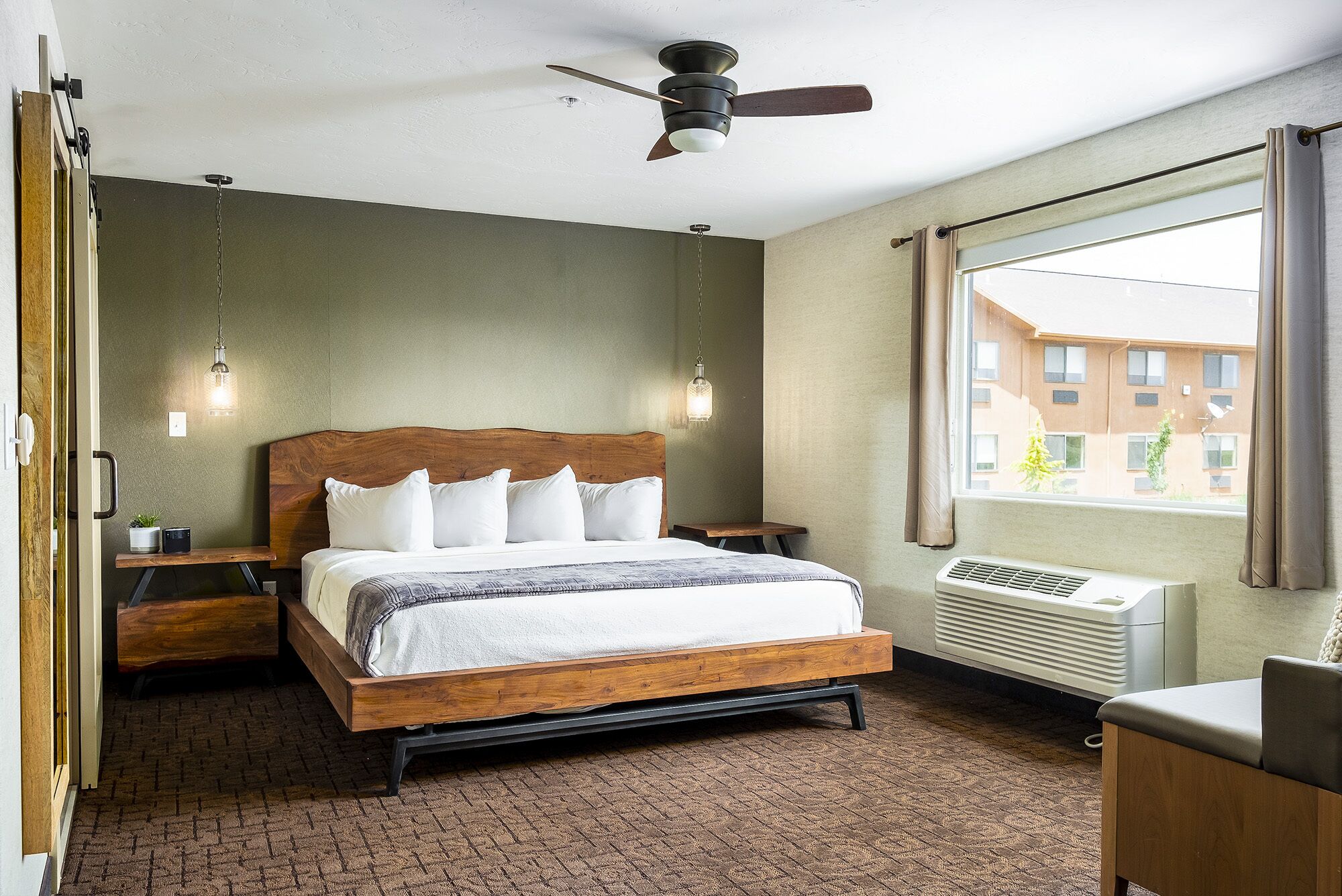 A bedroom with a wooden bed, a ceiling fan, a window with curtains, a bedside table, and a radiator.