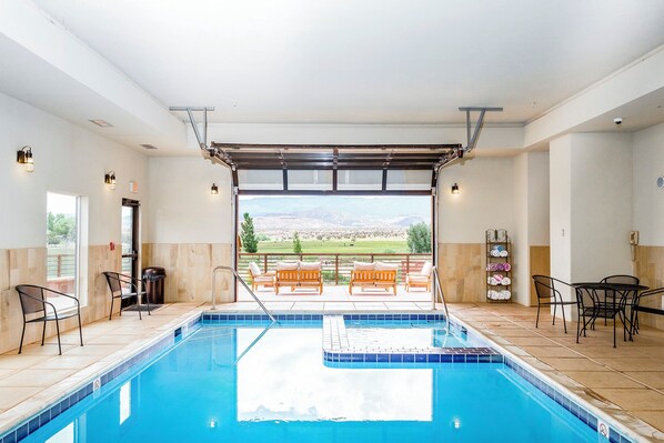 A swimming pool with a view of mountains, outdoor seating, and a covered area with a pergola. - Red Sands Hotel & Spa (Torrey)
