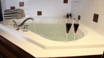 Una bañera grande con dos copas de vino tinto.