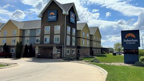 Un hotel de varios pisos con un letrero llamativo que dice "Suburban Studios".
