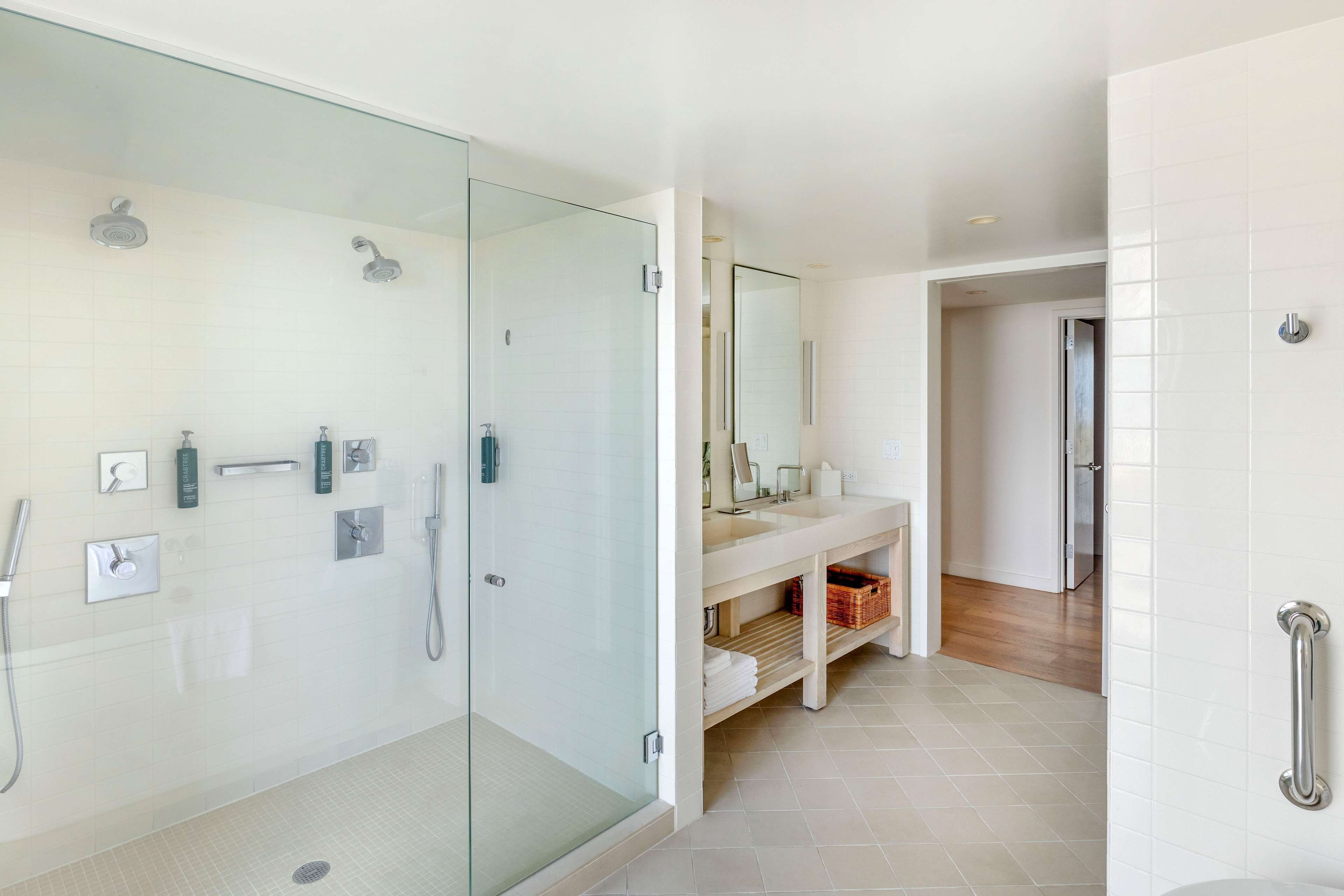 A modern bathroom with a glass-enclosed shower, a vanity with a mirror, and a toilet.