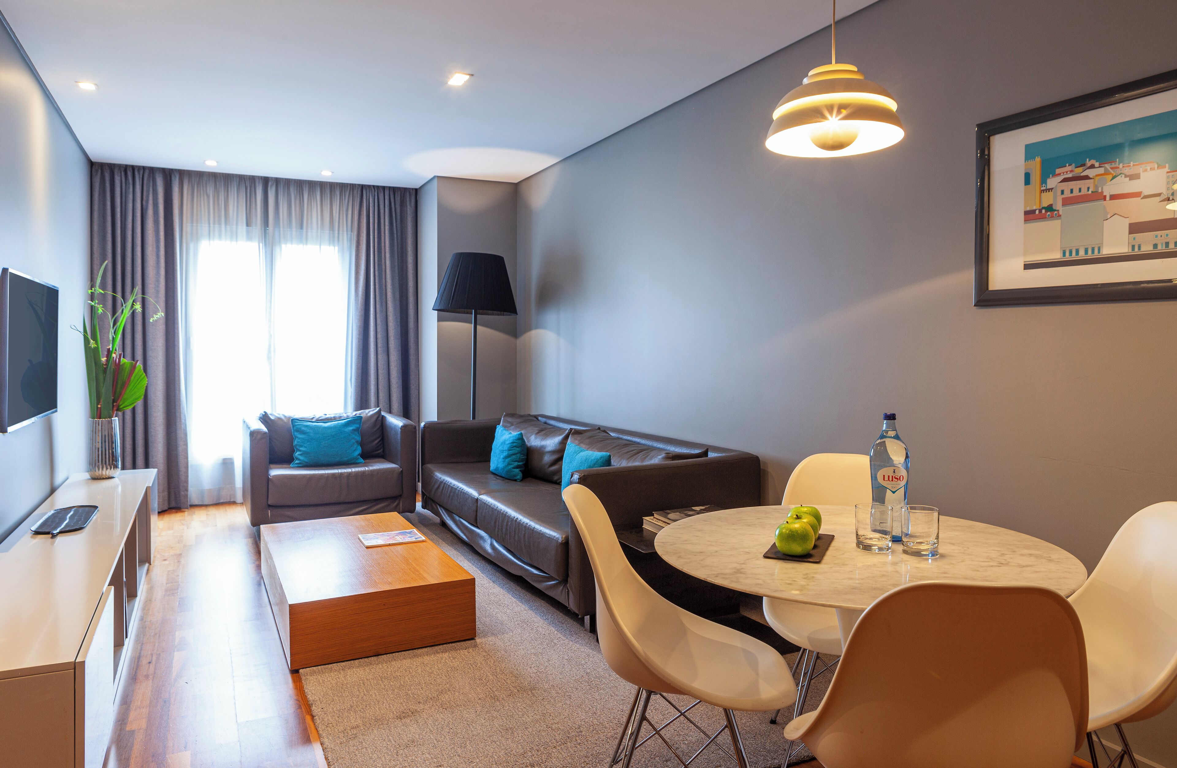 A modern living room with a sofa, coffee table, and dining area.