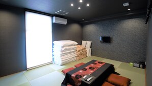 Une chambre d’hôtel moderne dotée d’un grand lit, d’une télévision à écran plat et d’une grande fenêtre laissant entrer la lumière naturelle.