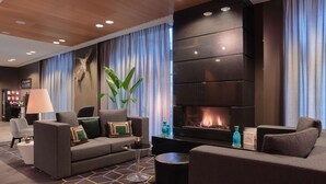 Ein modernes Wohnzimmer mit einer Couch, Sesseln, einem Couchtisch und einem Kamin.