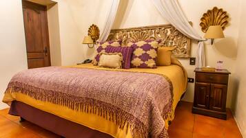 Un dormitorio con cama, mesita de noche, lámpara y puerta.