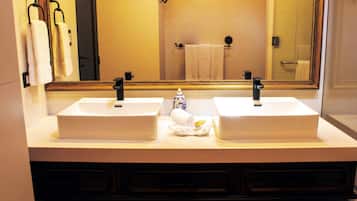 A bathroom with two sinks, a mirror, and a towel rack.