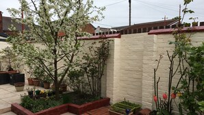 A garden with potted plants and a brick wall. - The Address (Blackpool)