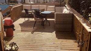A wooden deck with a table and chairs, surrounded by a wooden fence, and overlooking a residential area. - The Purple Tree Guest House (Torquay)