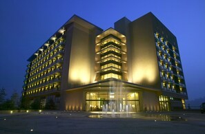 A modern hotel with a central entrance, multiple floors, and a fountain in front. - Fleur de Chine Hotel (Yuchi)