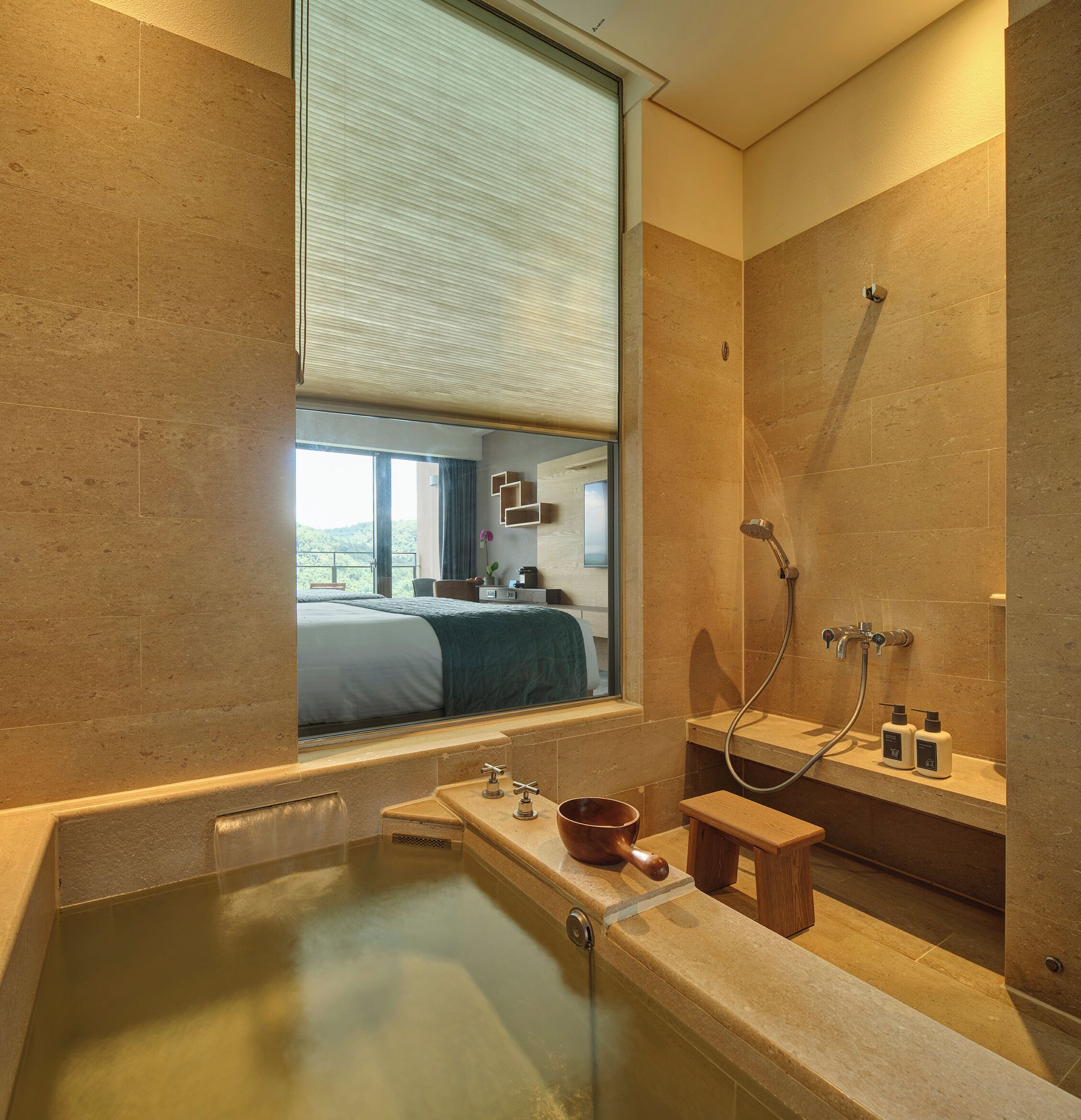 A modern bathroom with a bathtub, a shower, and a window with blinds.