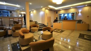 A hotel lobby with a reception desk, a bar area, and several seating options. - Lebed (Ohrid)