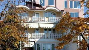 A multi-story hotel with a prominent entrance, balconies, and a sign reading "HOTEL LEBED".