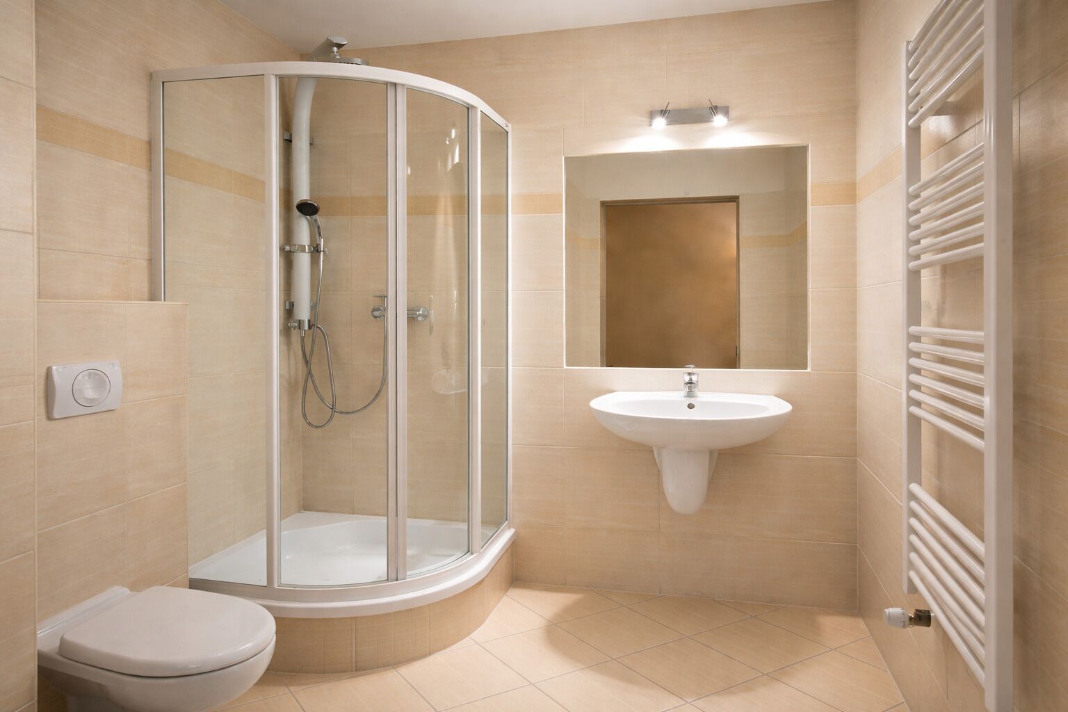 A bathroom with a glass shower enclosure, a pedestal sink, a toilet, and a towel rack.
