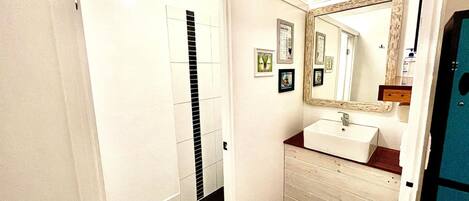 A bathroom with a white sink, a mirror, and a toilet.