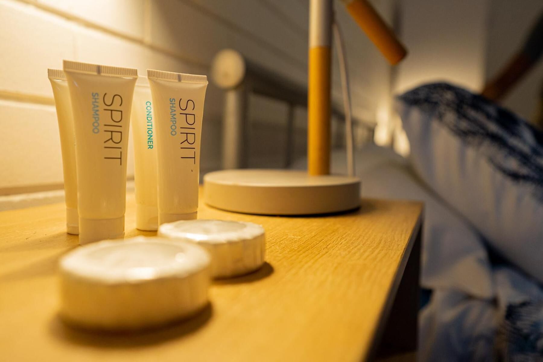 A bathroom counter with three tubes labeled 'SPIRIT SHAMPOO' and two round containers.