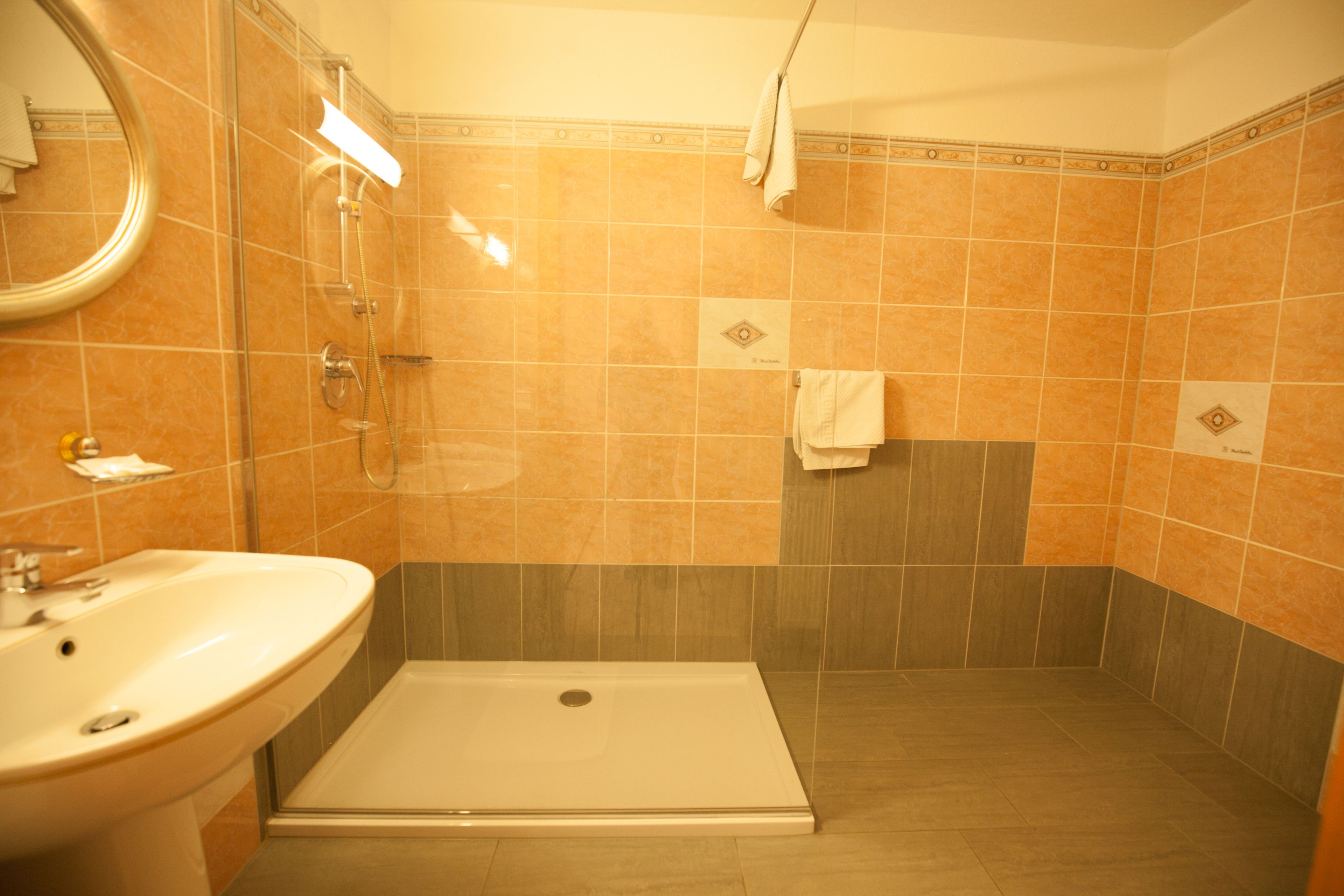 Casa de banho com lavatório, chuveiro e cabine de hidromassagem.