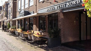 A hotel named "HOTEL PETT NORD" with outdoor seating and a brick facade. - Petit Nord (Hoorn)