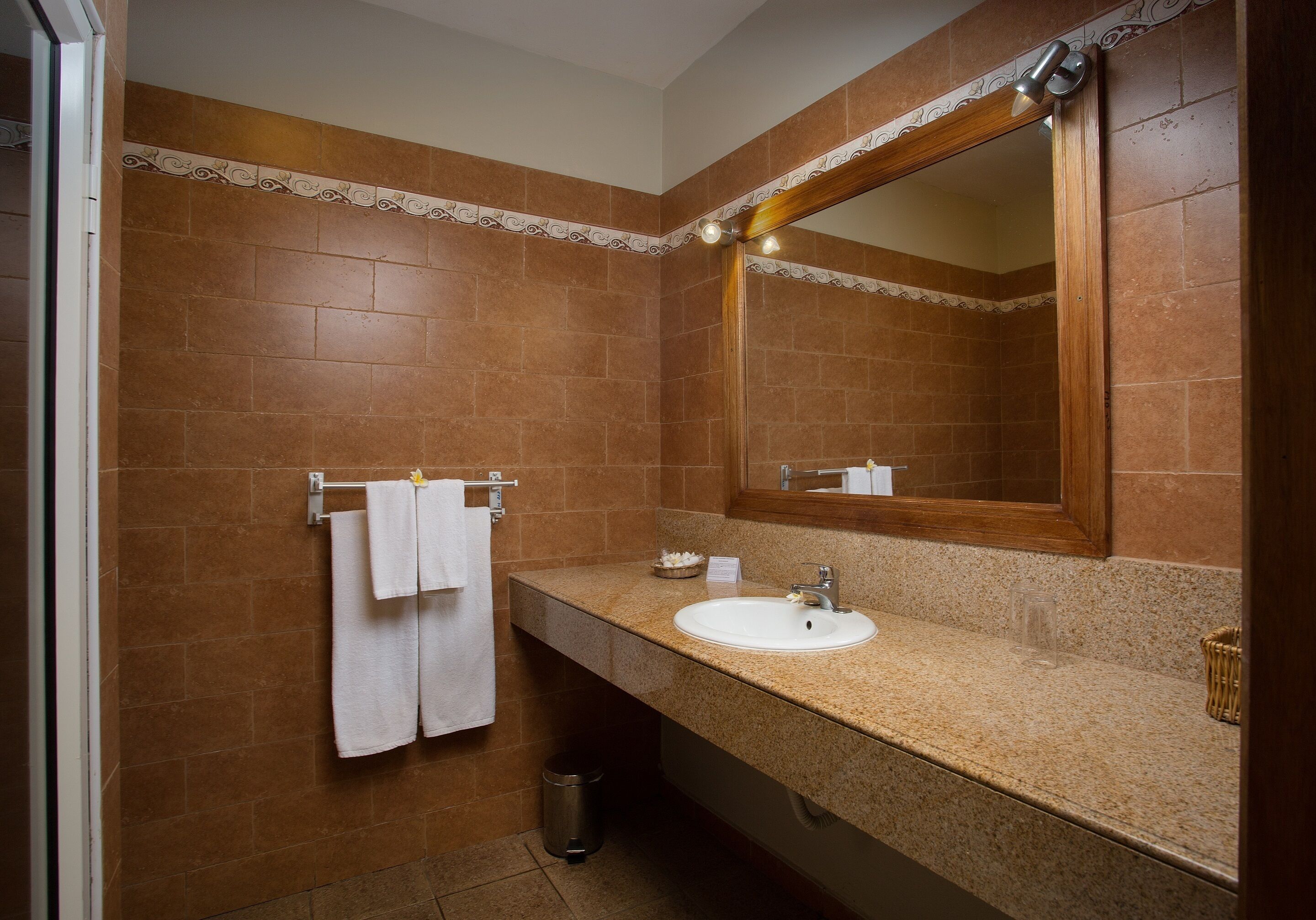 A bathroom with a sink, mirror, and towel rack.