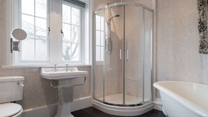 A bathroom with a toilet, sink, shower, and bathtub. - The Oratory (Yelverton)