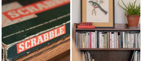 Une bibliothèque remplie de divers ouvrages et un tableau encadré représentant un oiseau.