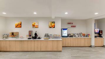 Un espace d’accueil propre et moderne, doté d’un comptoir, de machines à café et d’un réfrigérateur.