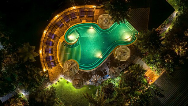 An aerial view of a resort with a swimming pool, sun loungers, and a landscaped garden area. - Hideaway Rio Celeste (Katira)