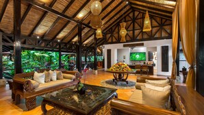 A spacious lobby with a high wooden ceiling, a large sofa, a coffee table, and a television in the background. - Hideaway Rio Celeste (Katira)