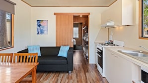 A compact living space with a sofa, dining table, and kitchenette. - Discovery Parks - Moama West (Moama)