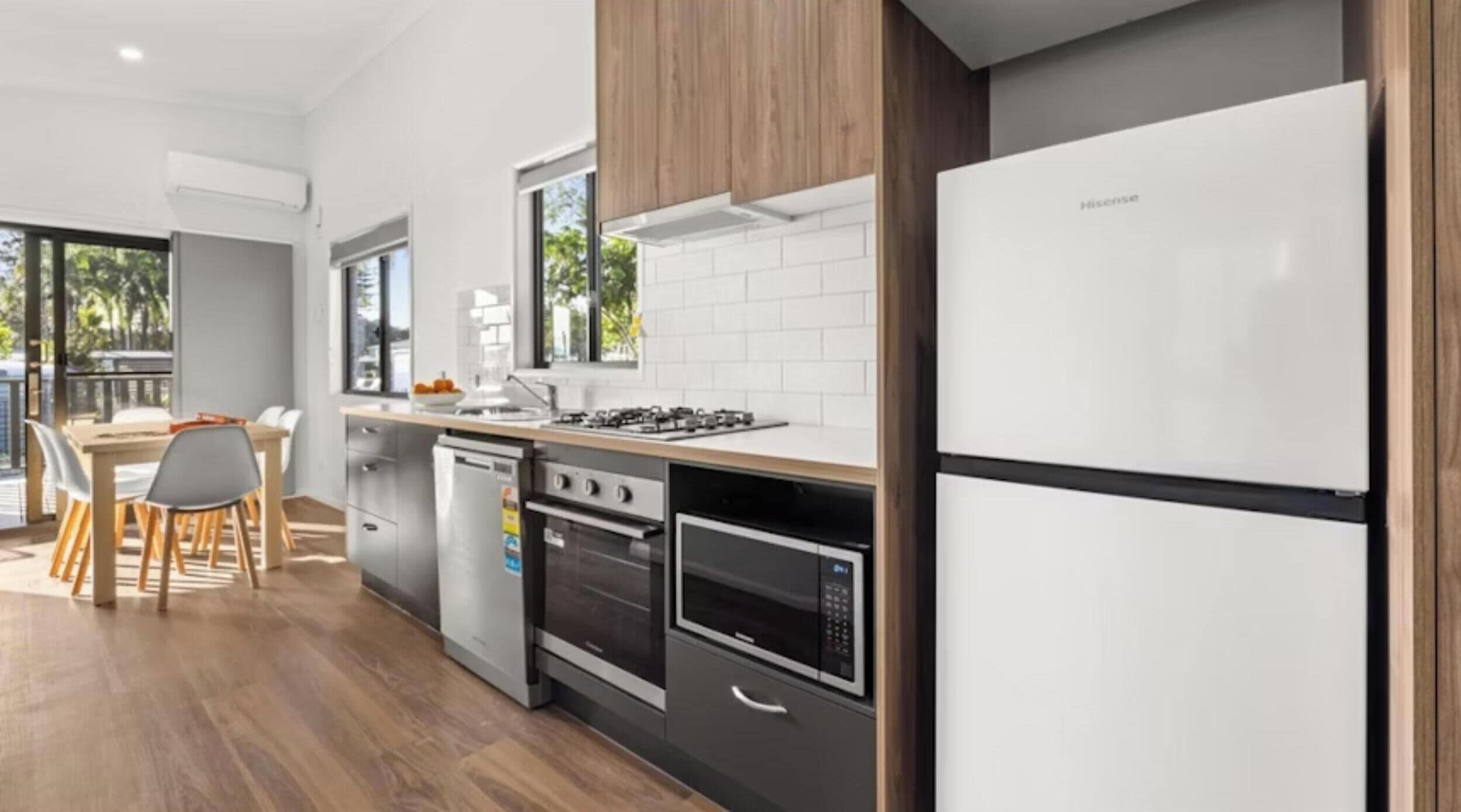 A modern kitchen with a built-in oven, dishwasher, and a Hisense refrigerator.
