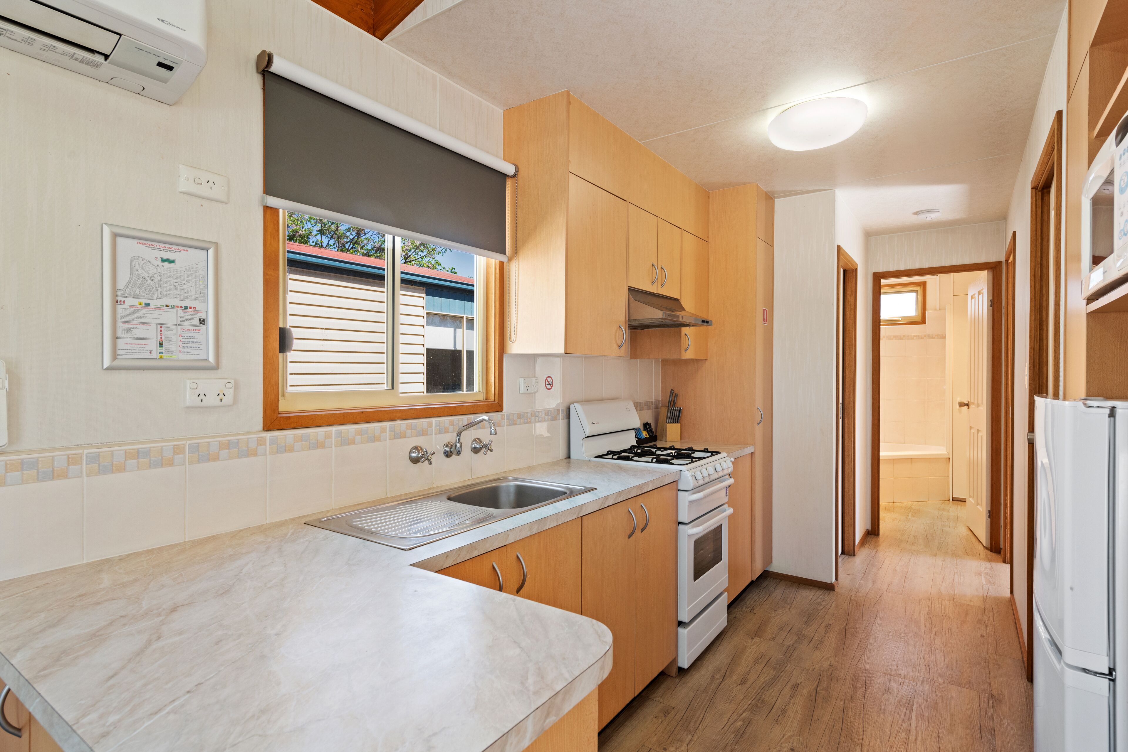 A kitchen with wooden cabinets, a stove, and a sink.