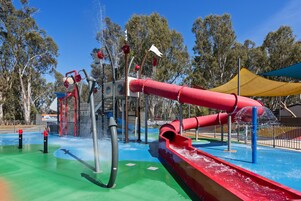Un área de juegos acuáticos con toboganes y chorros de agua.