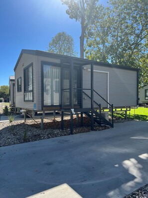 Situated on a concrete driveway, this single-story home features a modern design with a front entrance and small porch area.