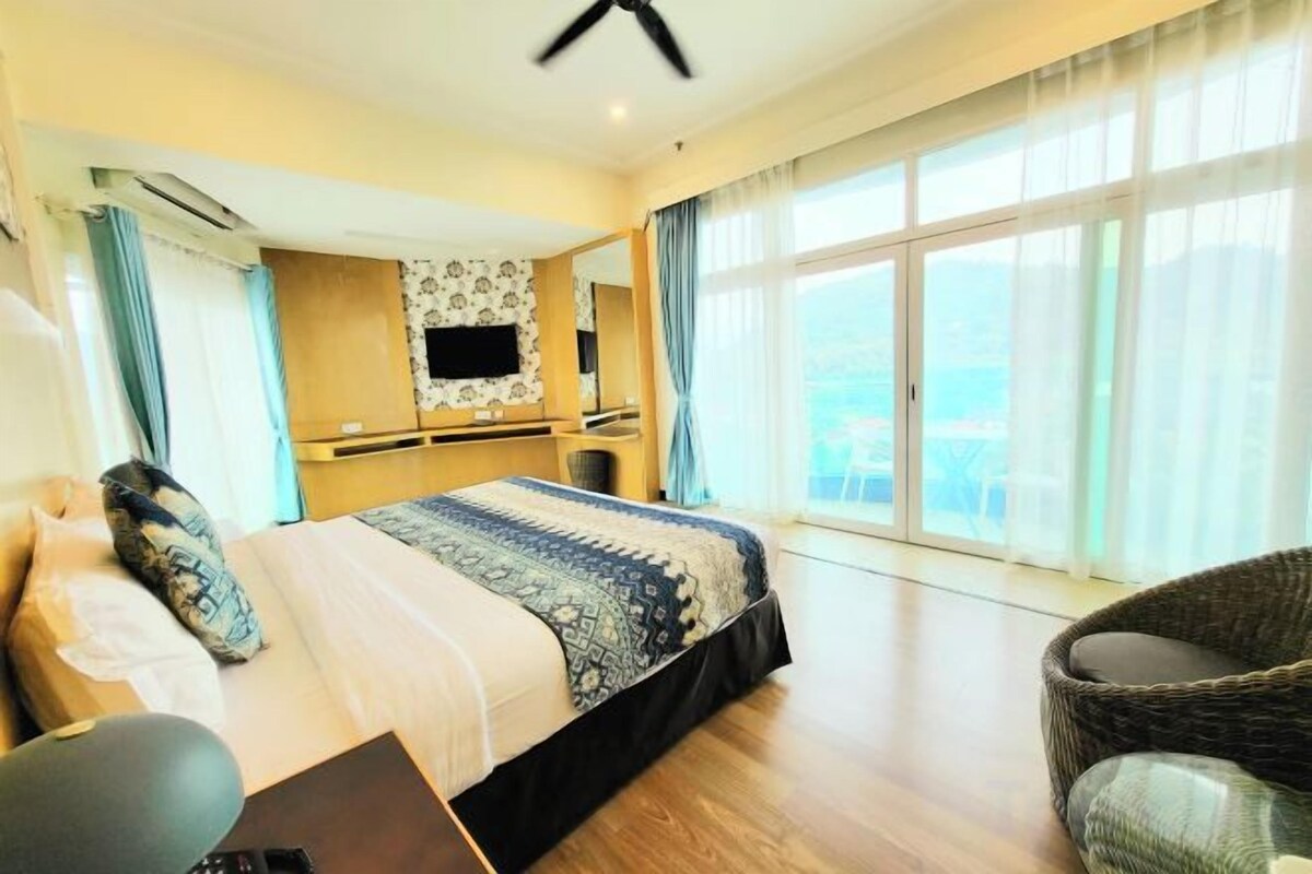 Ein Hotelzimmer mit einem großen Bett, einem Flachbildfernseher, einem Schreibtisch und Blick auf die Stadt.