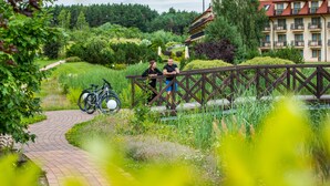 A pathway leading to a wooden bridge with a bicycle parked nearby. - Hotel Ossa Conference & Spa (Rawa Mazowiecka)