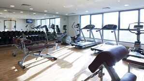 A gym with various exercise equipment, including treadmills, elliptical machines, and free weights. - Grand Belle Vue (Dubai)