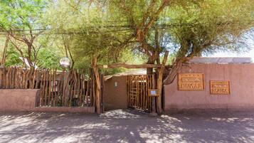 A rustic wooden gate with a sign for 'Kimal' and 'Paacha' hotels.